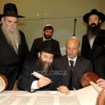R. Shneur Henig at the Kotel finishing a Torah with Rabbi Kaminetzky and Gennadiy Bogolyubov at the Kotel
